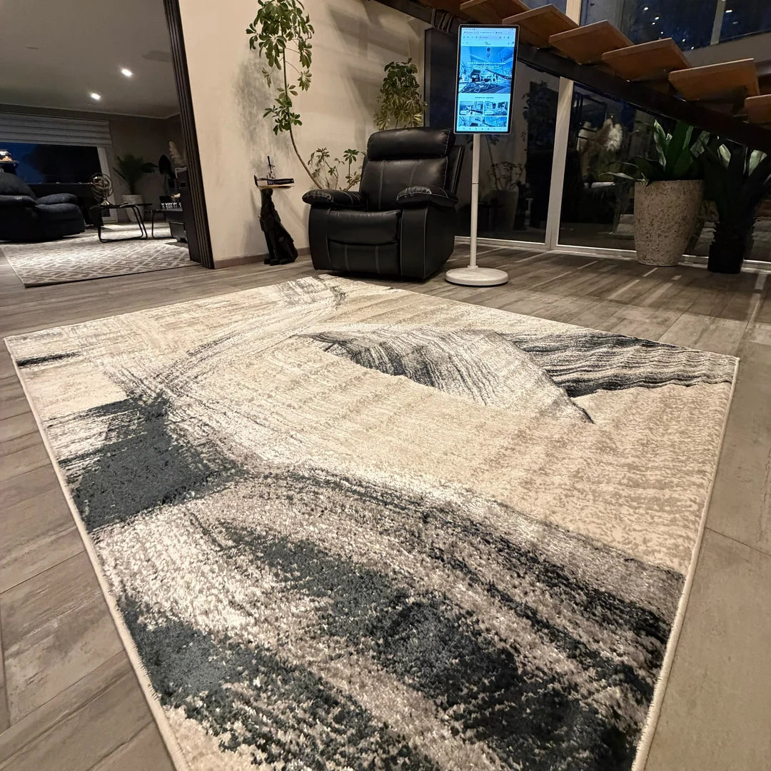 Alfombra Tokio Onnas en living, un trazo ancho en gris y carbón que cruza el crema como una pincelada
