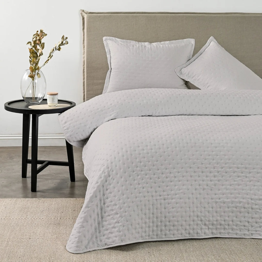 Quilt Drops Gris Claro American Family sobre la cama
