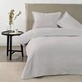 Quilt Drops Gris Claro American Family sobre la cama