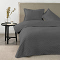 Quilt Drops Gris Oscuro American Family sobre la cama