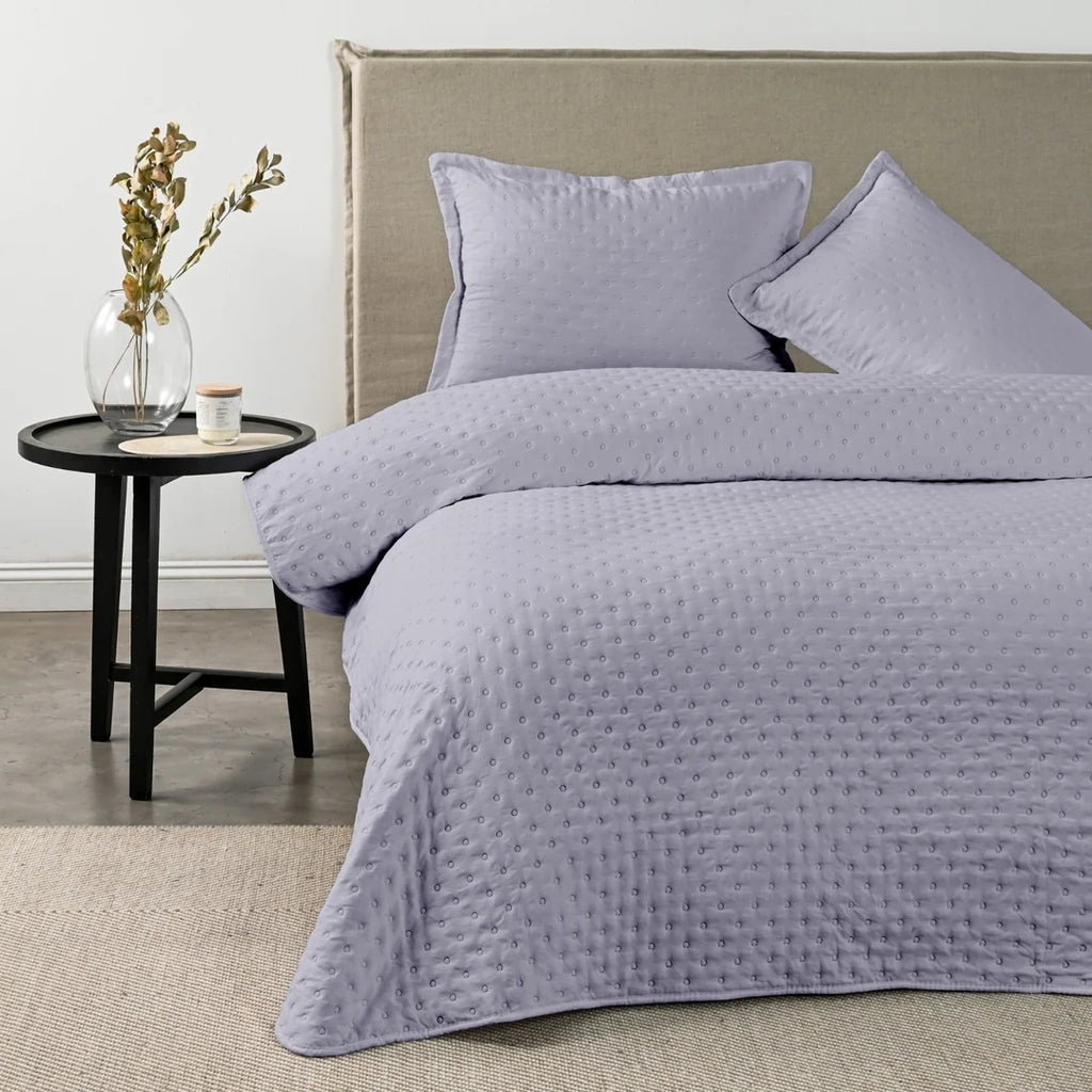 Quilt Drops Lila American Family sobre la cama