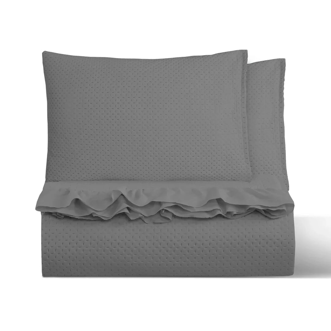 Quilt liso gris 2 plazas Martiné sobre cama, con fundas a juego