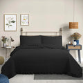 Quilt liso negro 2 plazas Martiné sobre cama, con fundas a juego