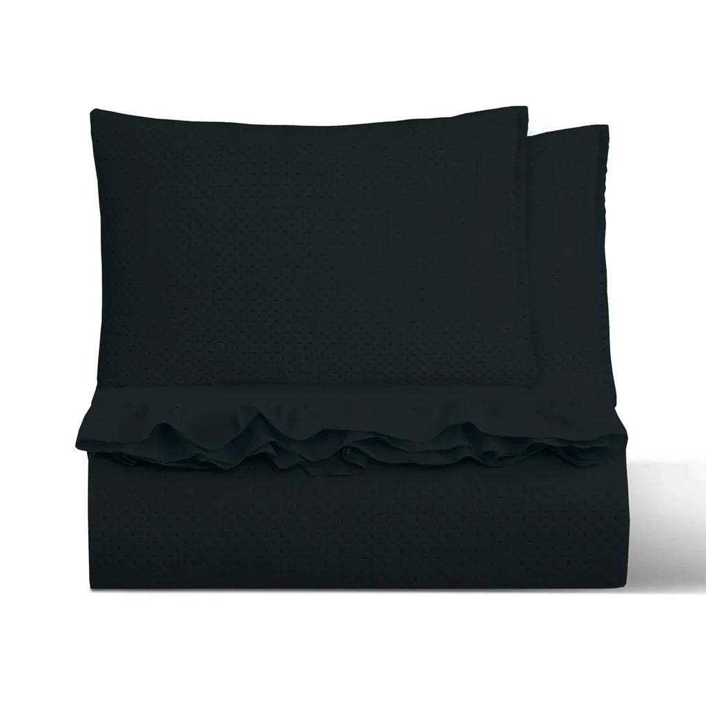 Quilt liso negro 2 plazas Martiné sobre cama, con fundas a juego