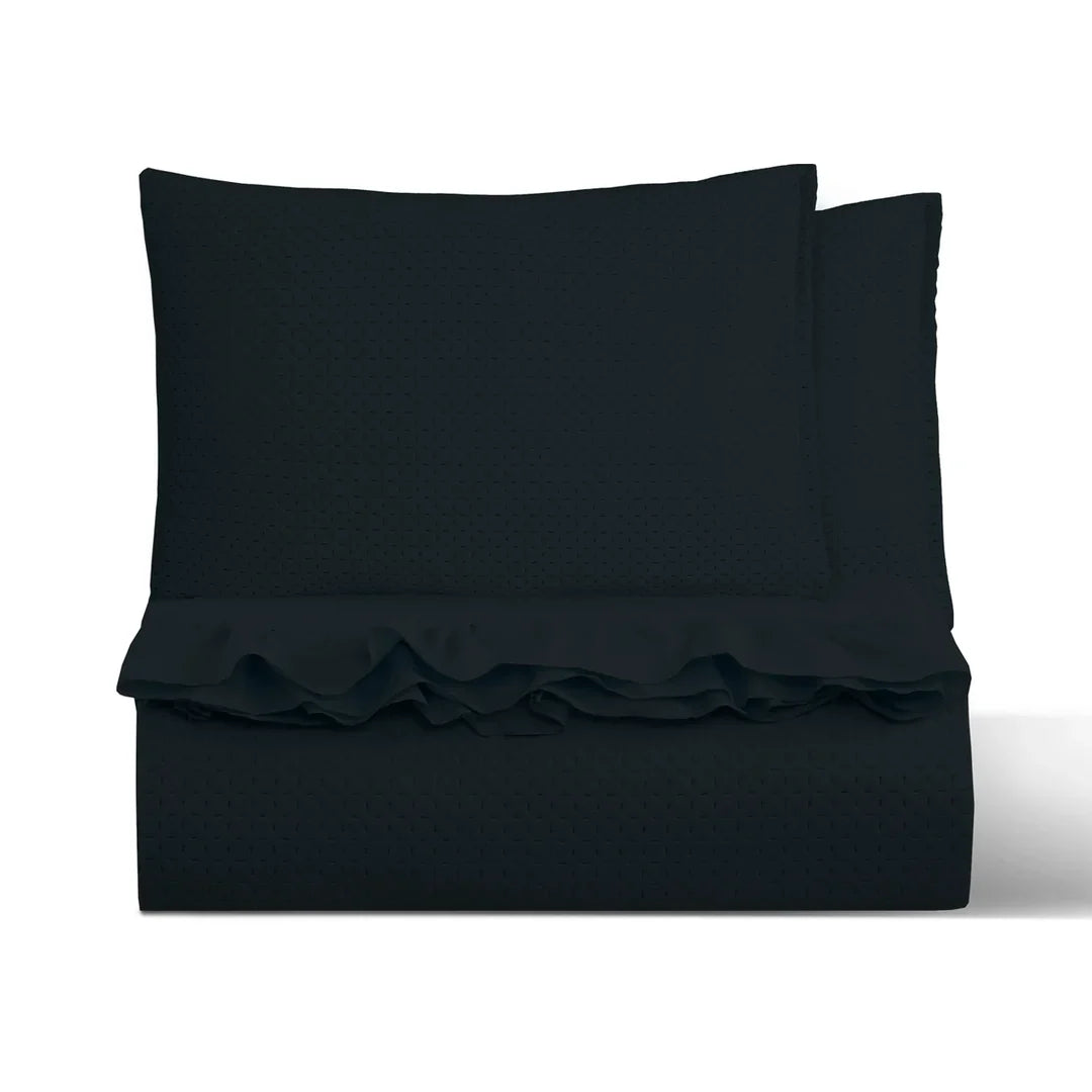 Quilt liso negro 2 plazas Martiné sobre cama, con fundas a juego