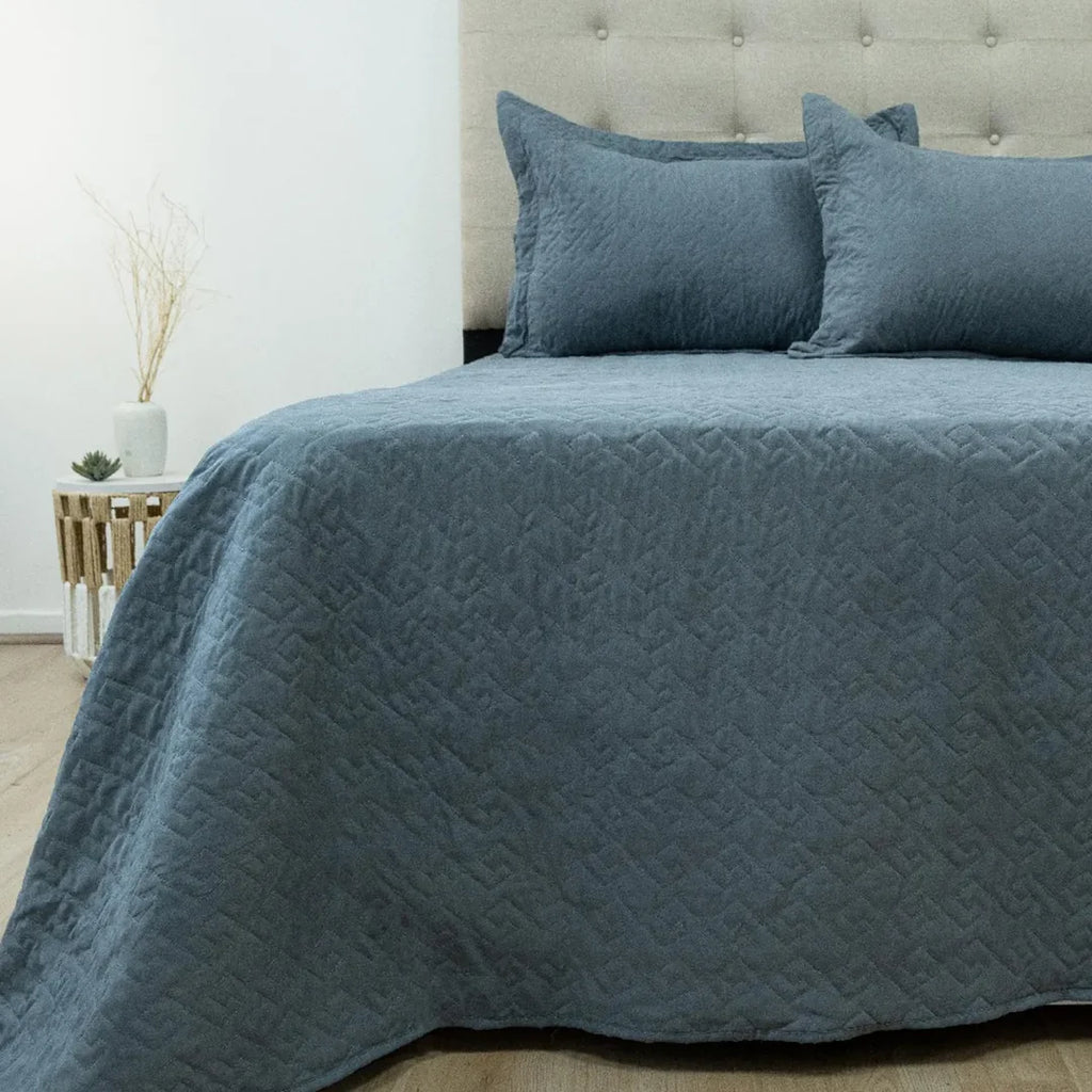 Quilt Velvety azul grisáceo Doral sobre cama, superficie afelpada