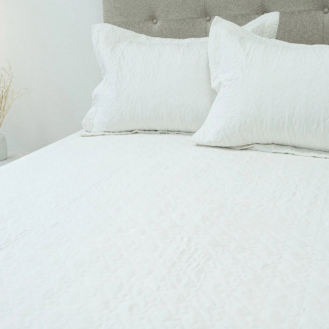 Quilt Velvety blanco Doral sobre cama, superficie afelpada