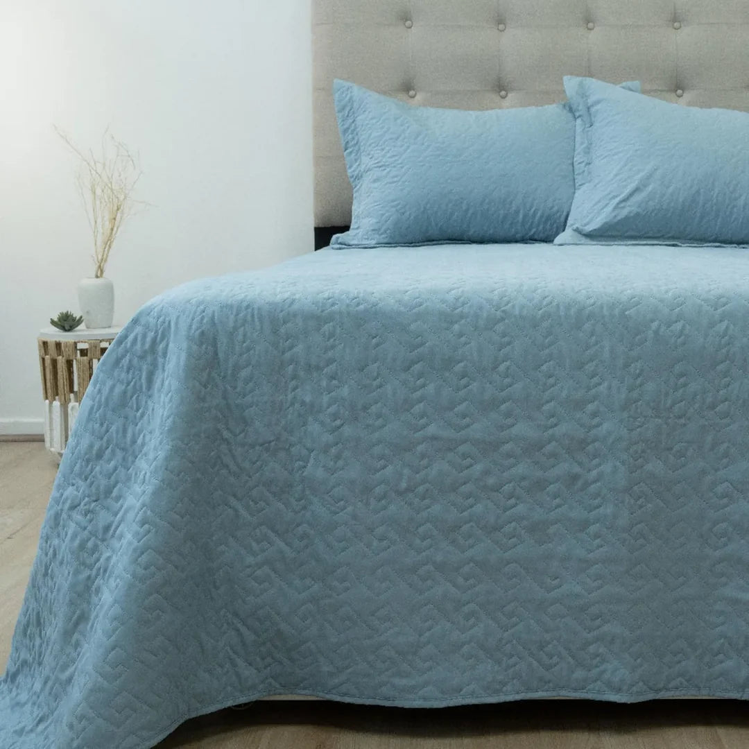 Quilt Velvety celeste Doral sobre cama, superficie afelpada