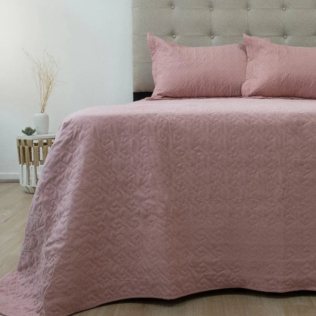 Quilt Velvety rosado Doral sobre cama, superficie afelpada