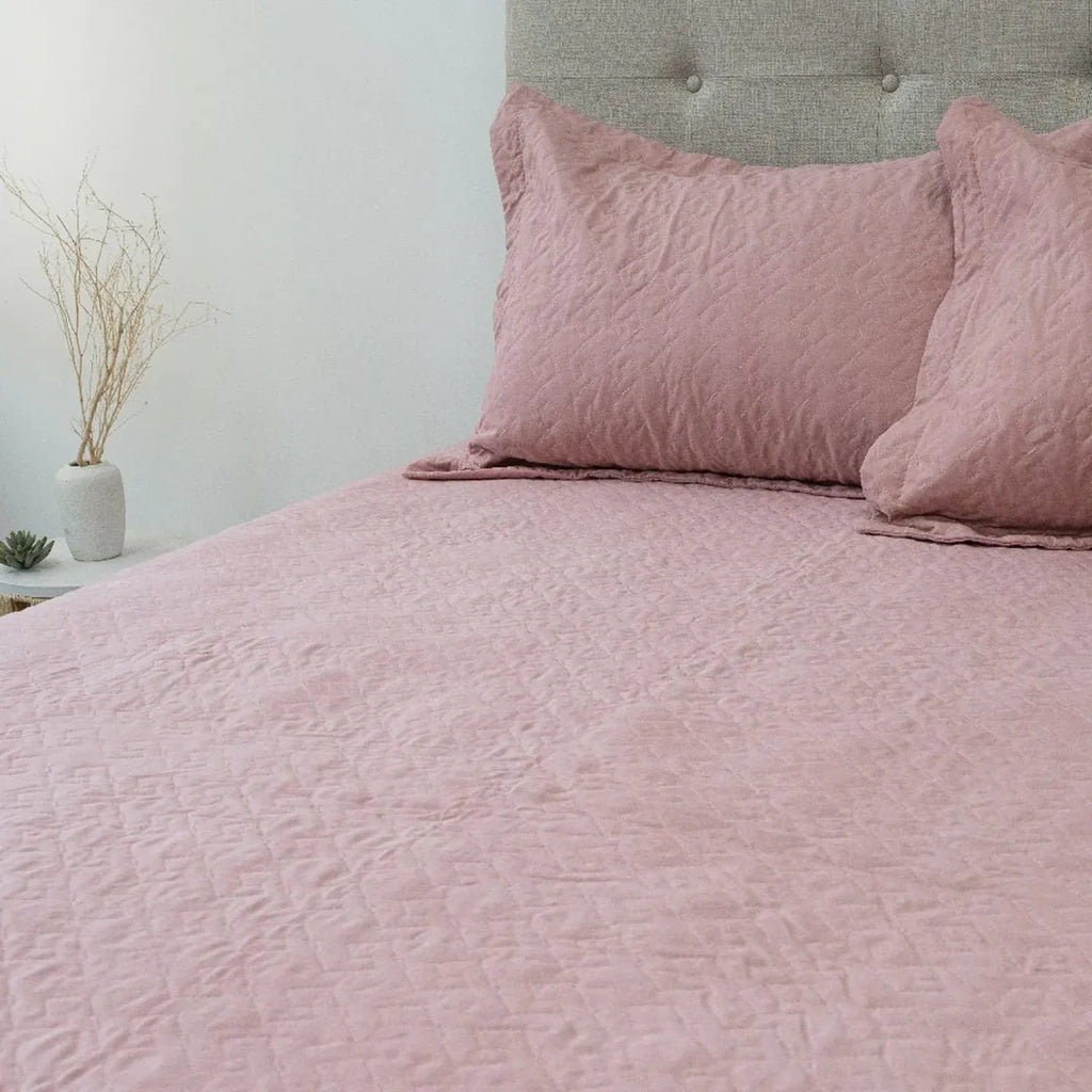 Quilt Velvety rosado Doral sobre cama, superficie afelpada