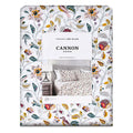 Sábana Flutter Cannon sobre cama, floral en mostaza, verde y granate sobre blanco